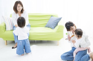 Parlak odada çocuklarla oynayan kadınlar