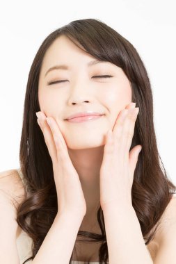 Yüzünde elleri olan güzel Asyalı bir kadın. 