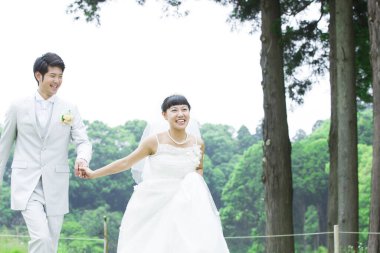 Parkta poz veren Asyalı gelin ve damat 