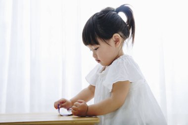 Oturma odasında oynayan küçük tatlı bir Japon kız.