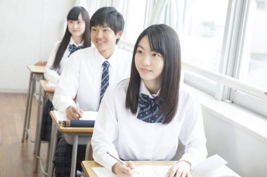 Genç Japon öğrenciler sınıfta okuyor.