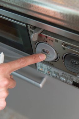 Asyalı işçi mutfak aletlerini kontrol ediyor.