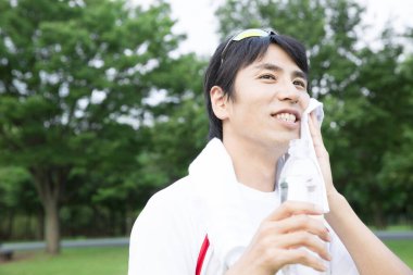 Yürüyüşten sonra su içen genç bir adamın portresi