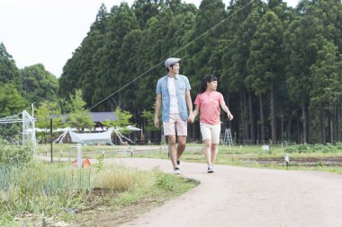 Genç Japon erkek ve kadın tatilde yolda yürüyorlar.