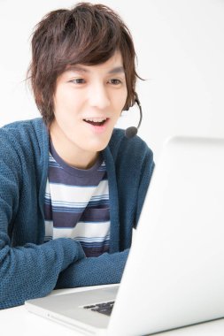 Laptop kullanan Asyalı adam.