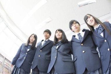 Sınıfta sarılan genç Japon öğrencilerin portresi.