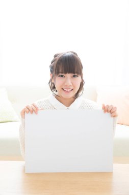 Boş beyaz işaret tutan Asyalı kadın