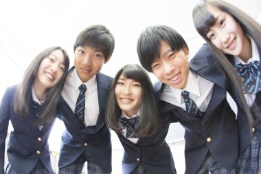 Sınıfta sarılan genç Japon öğrencilerin portresi.