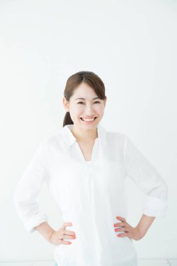 Beyaz arka planda elleri akimbo olan güzel Japon iş kadını. 