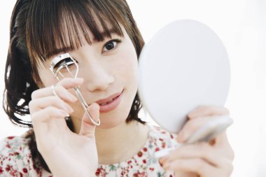 Makyaj fırçası olan Asyalı genç kadın.