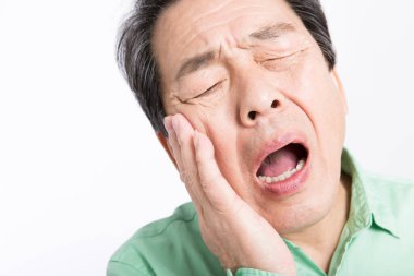 Diş ağrısı olan Asyalı bir adamın portresi. 