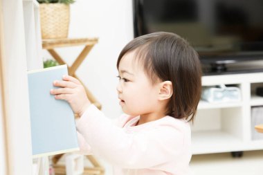 Küçük Asyalı kız evde oynuyor.