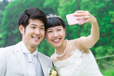 Asyalı gelin ve damat selfie çekiyor. 