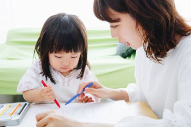 Annesiyle resim çizen tatlı Asyalı kız.