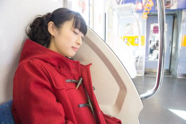 Tren istasyonunda uyuyan Asyalı kadının portresi.