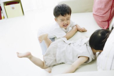 İki çocuk yerde gülüp oynuyor.