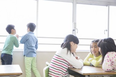 Çocuklar konuşuyor ve pencereden dışarı bakıyor.