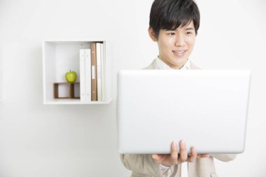 Bilgisayarlı Asyalı adam ofiste çalışıyor. 