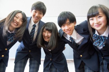 Sınıfta sarılan genç Japon öğrencilerin portresi.