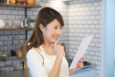 Asyalı kadın evde tablet kullanma