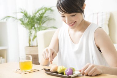 Kahvaltı hazırlayan Asyalı kadının portresi.