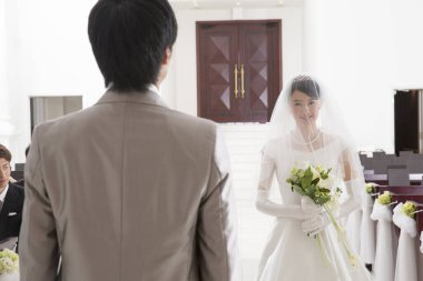 Asyalı gelin ve damat içeride düğün töreninde.