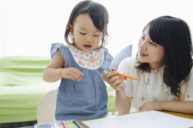 Annesiyle resim çizen tatlı Asyalı kız.