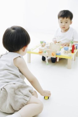 Evde oyuncaklarla oynayan sevimli Japon çocukları.