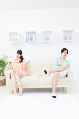 Evdeki kanepede oturan kızgın genç çift.