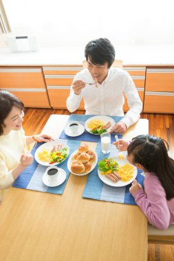 Aile mutfakta kahvaltı yapıyor.