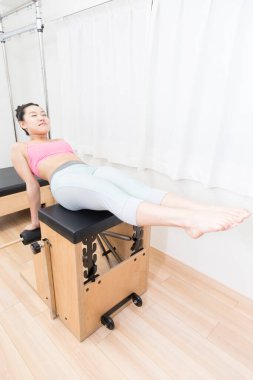 Spor giyinen Japon kadın iç mekanda antrenman yapıyor.