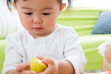 Evdeki oturma odasında oynayan küçük tatlı bir Japon kız.