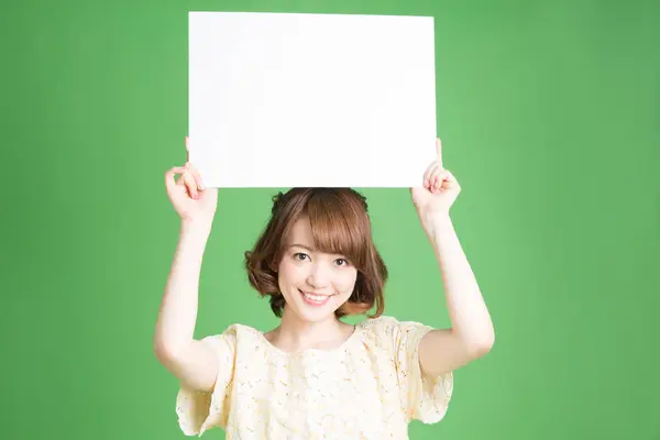 日本美女肖像 背景为绿色 手持空白卡片 — 图库照片