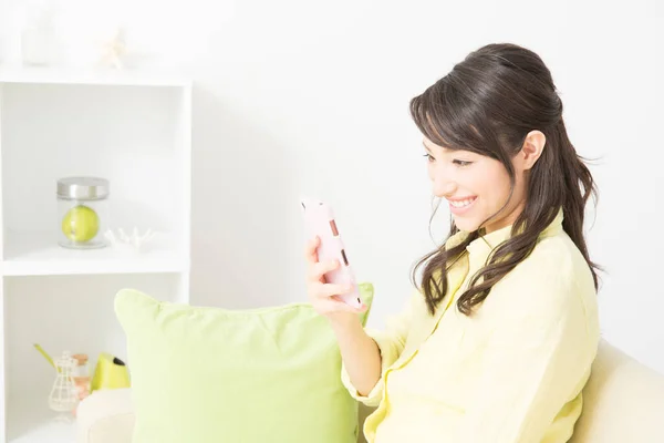 woman with mobile phone on sofa