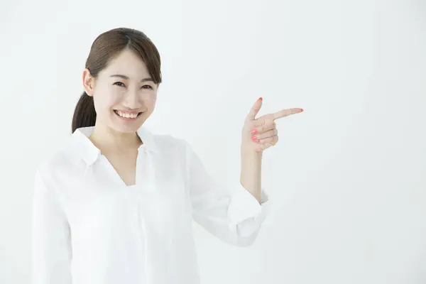 Piękna Japonka Pokazuje Coś Palcem Wskazującym Białym Tle — Zdjęcie stockowe