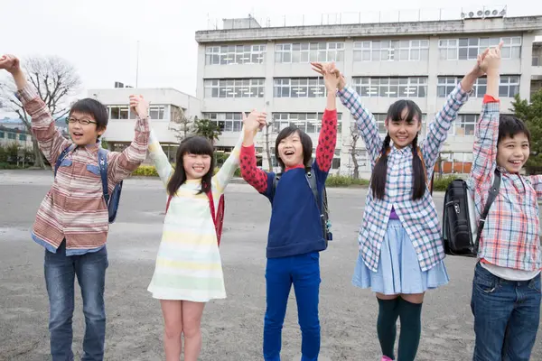 一群日本孩子在学校操场上手挽手 — 图库照片