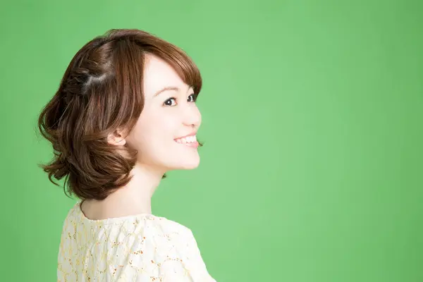 Yeşil Arka Planda Gülümseyen Güzel Japon Kadının Portresi — Stok fotoğraf