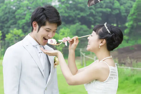 Asian wedding couple, bride feeding groom with cake