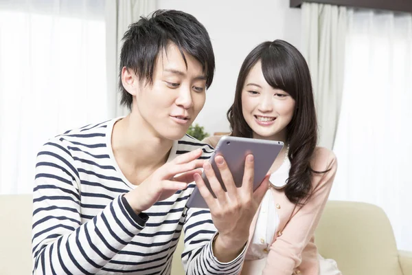 Mutlu Asyalı Çift Evde Tablet Kullanıyor — Stok fotoğraf
