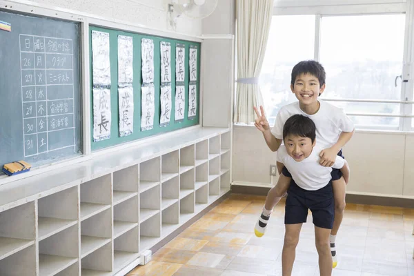 教室で楽しんでいる2人のアジアの少年 — ストック写真