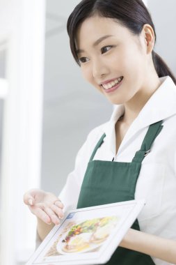 Garson ziyaretçilere menüyü gösteriyor 