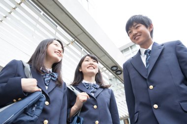 Çantalı gülümseyen Japon öğrencilerin portresi. 