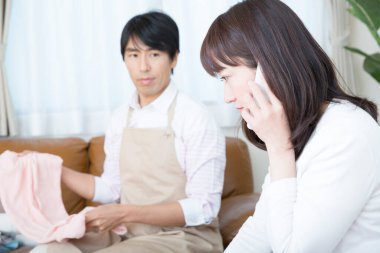 Kadın telefonda, erkek çamaşırları tutarken.