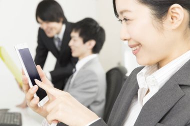 Akıllı telefon kullanan Asyalı genç kadının portresi