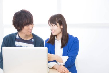 Dizüstü bilgisayarla çalışan iki genç öğrenci. 