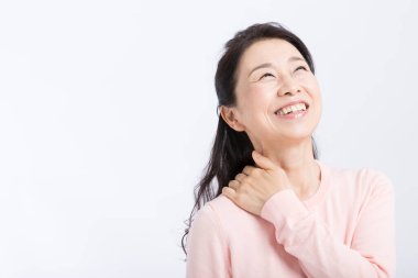 Boynu ağrıyan yaşlı bir Asyalı kadın beyaz tenli. 