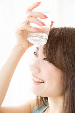 Asyalı kadın su içiyor.