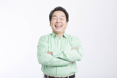 Mutlu Asyalı adam kolları bağlı gülümsüyor. 