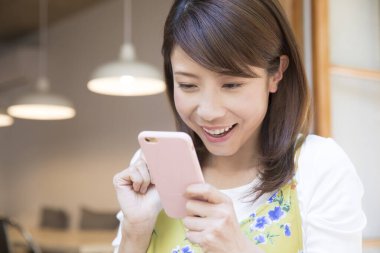 cep telefonu kullaranarak mutlu Asyalı kadın