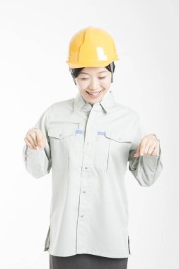 Güvenlik kaskı takmış kadın mühendis beyaz arka planda izole edildi